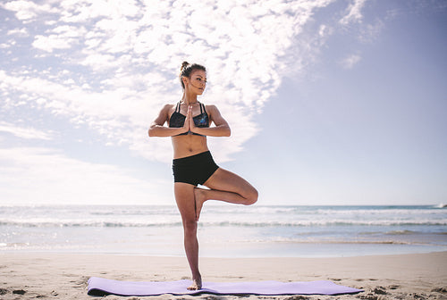 Sports woman doing yoga along the beach – Jacob Lund Photography