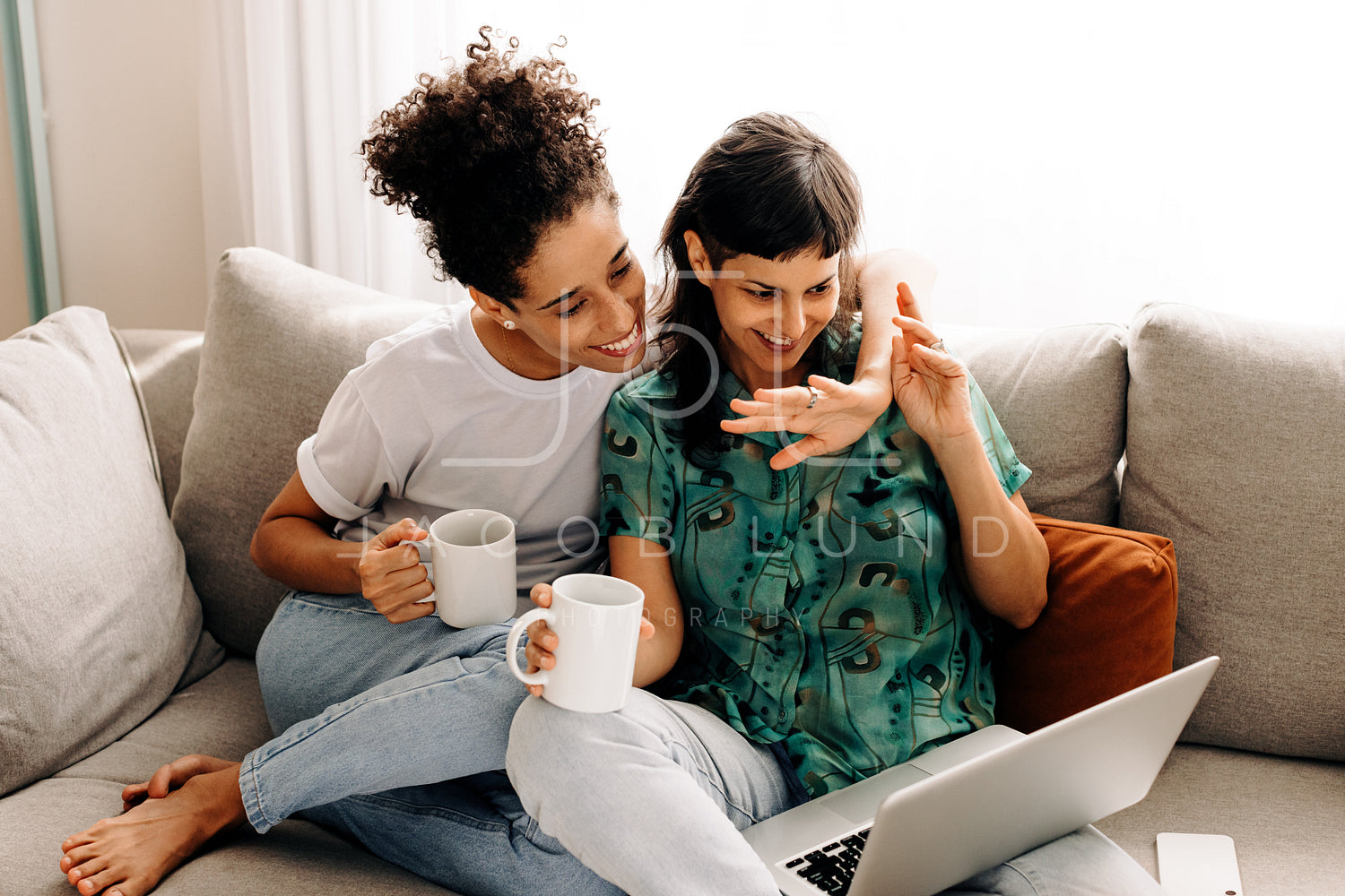 Happy lesbian couple video calling their friends at home – Jacob Lund  Photography Store- premium stock photo