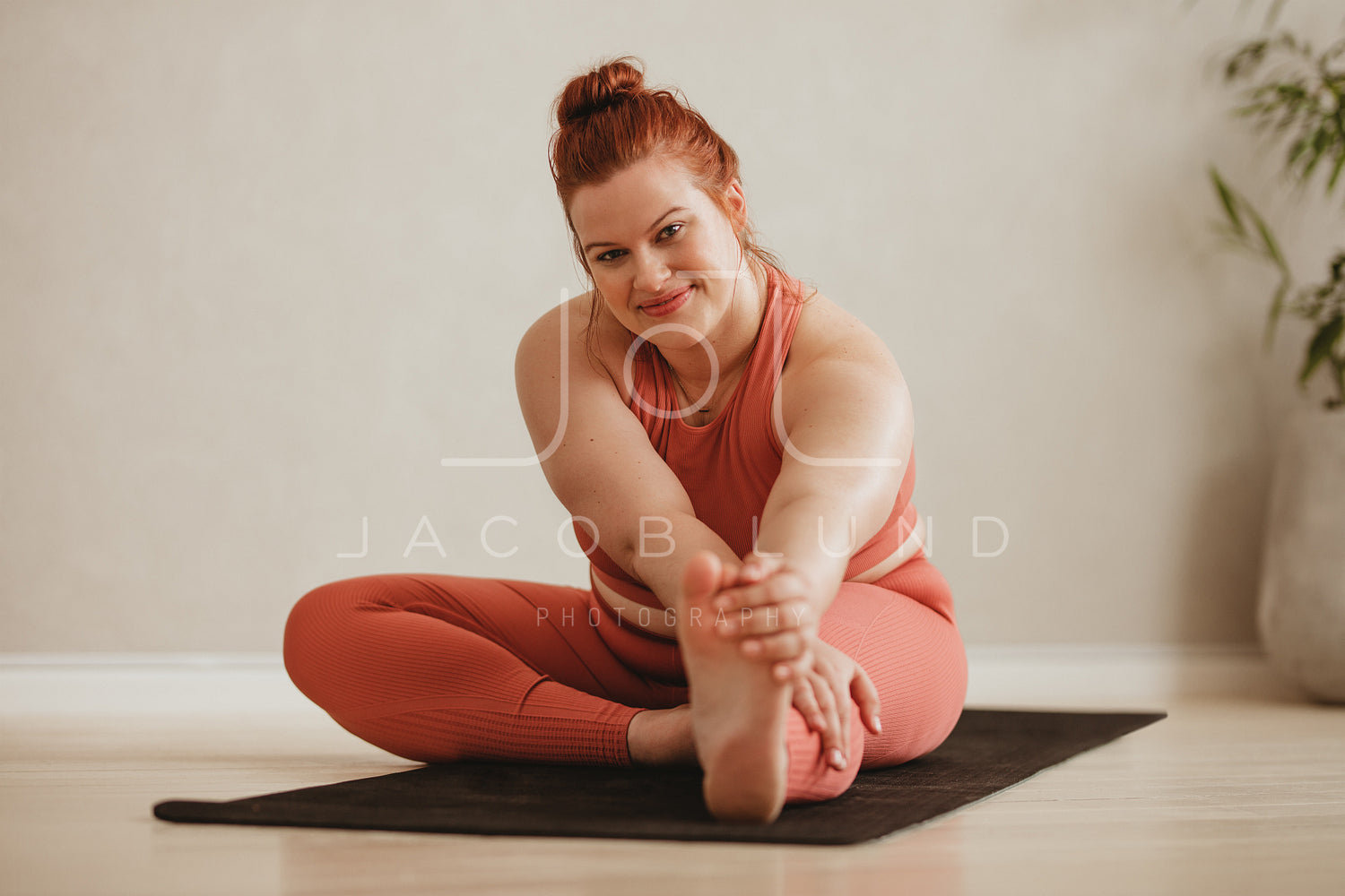 Woman doing yoga while watching instructional videos on laptop – Jacob Lund  Photography Store- premium stock photo