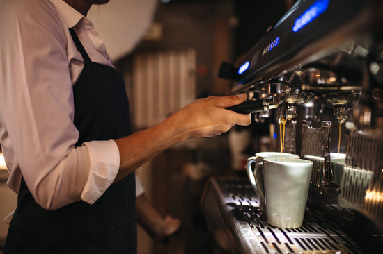 Smiling barista making espresso with a coffee maker – Jacob Lund  Photography Store- premium stock photo