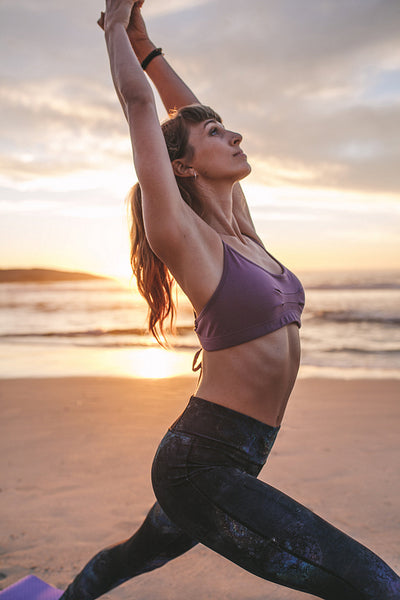 Young woman practicing yoga at beach