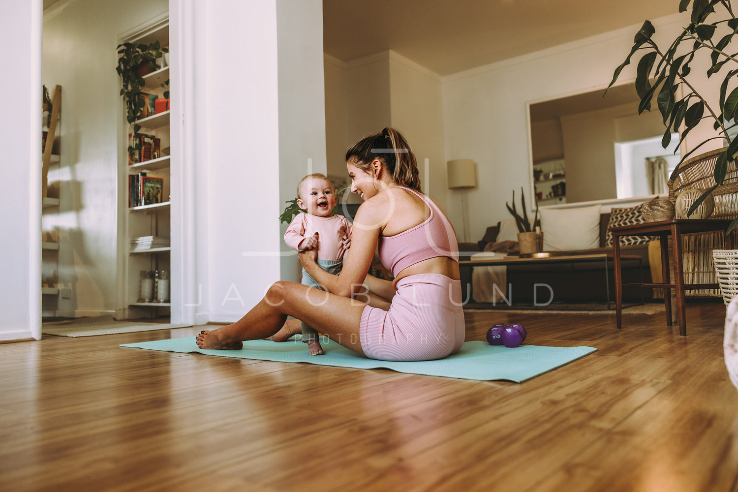 Young mother holding her adorable baby on an exercise mat – Jacob