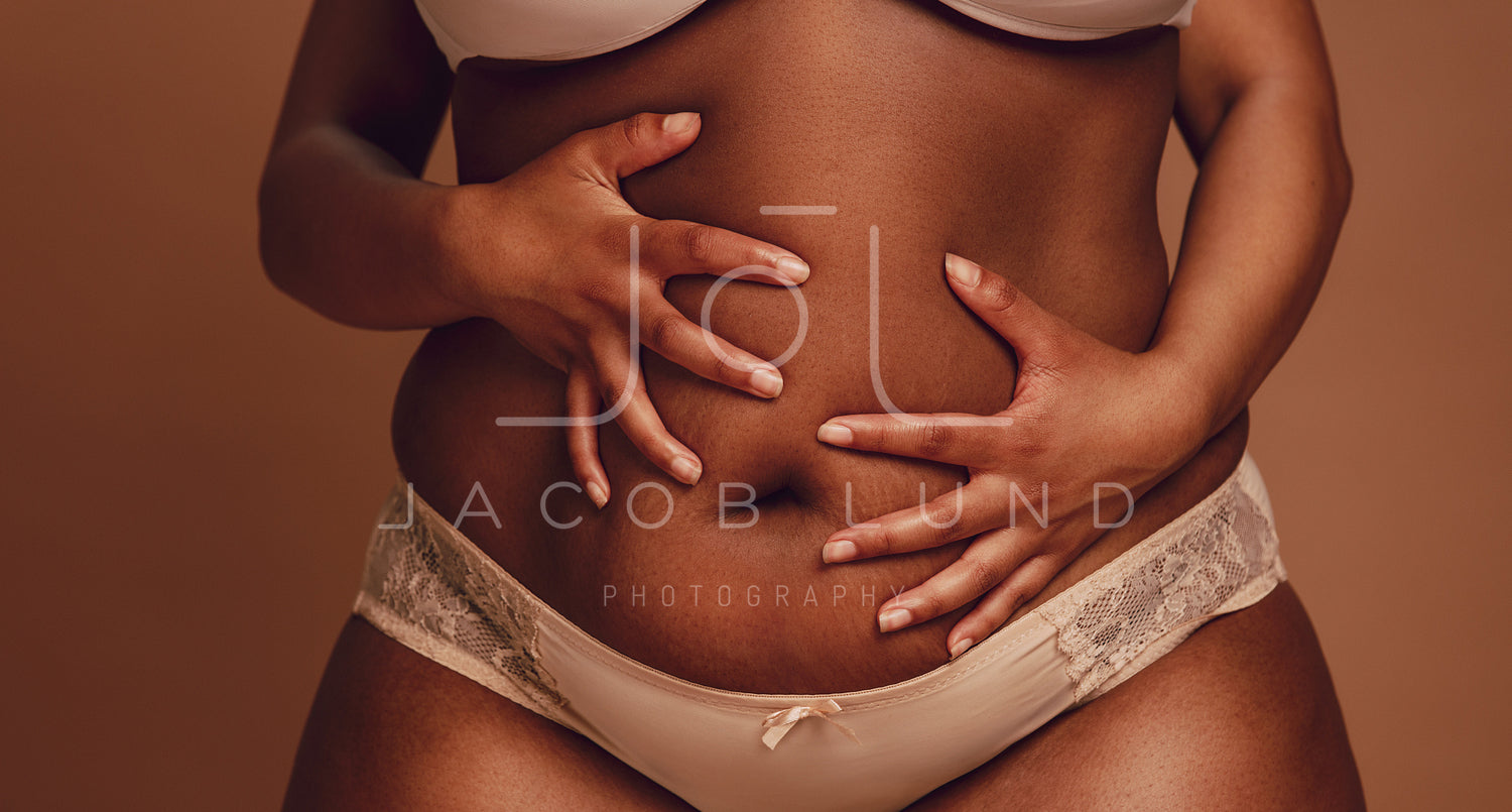 Plus size woman in lingerie holding her belly – Jacob Lund