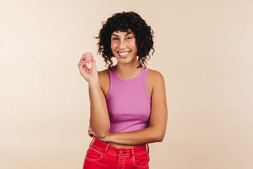 Unshaven young woman smiling cheerfully while wearing a bra and jeans.  Happy young woman embracing her natural body and underarm hair. Body  positive young woman making her own choice about her body.