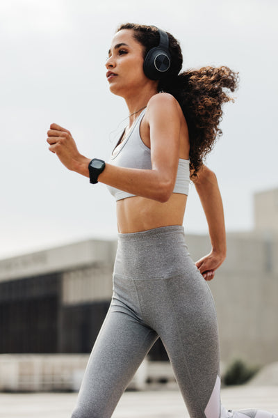 Woman runner in jogging outfit running on a street. fitness woman