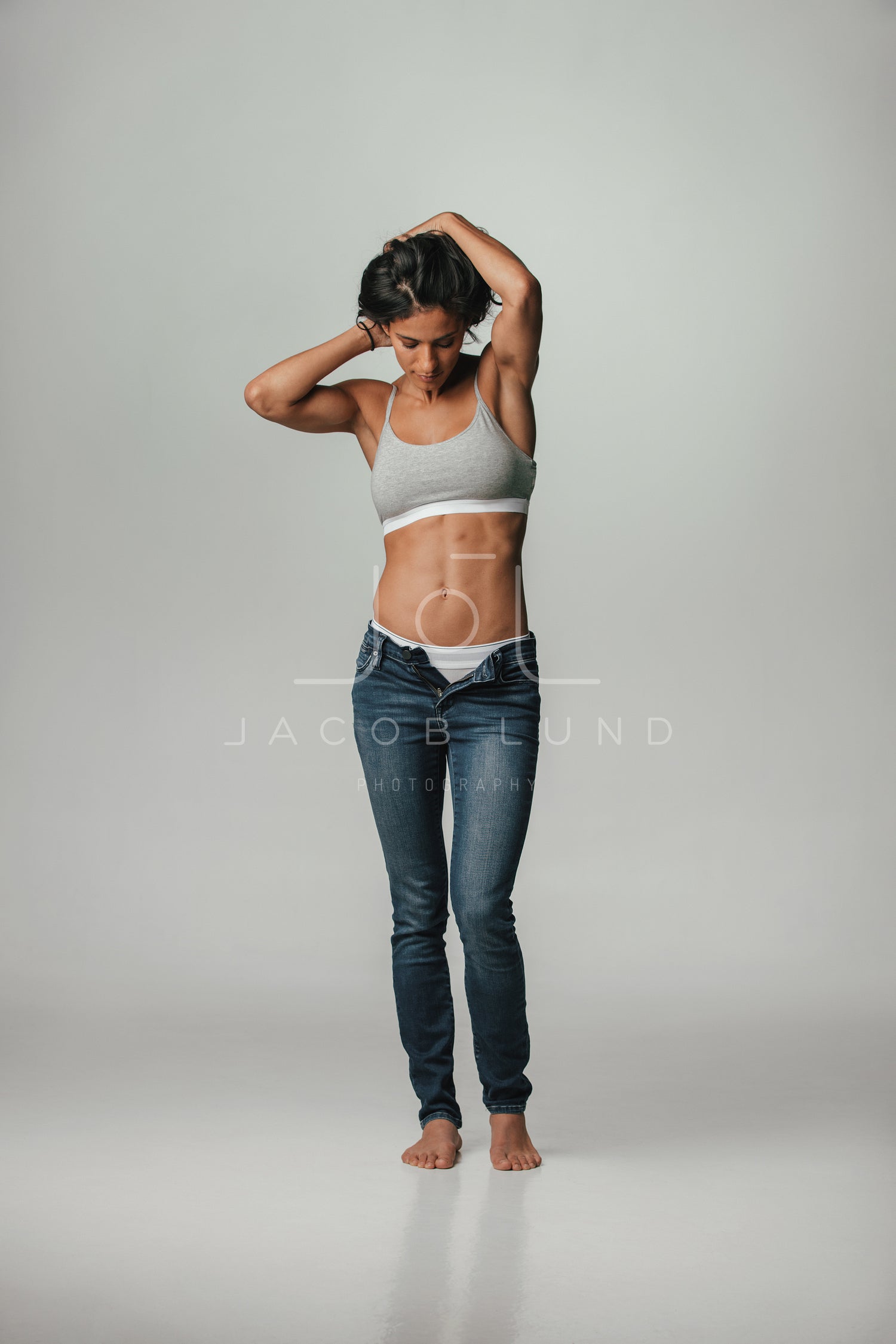 Young caucasian woman posing in blue bra and jeans. Stock Photo