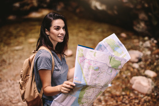 Beautiful woman hiker posing with a map