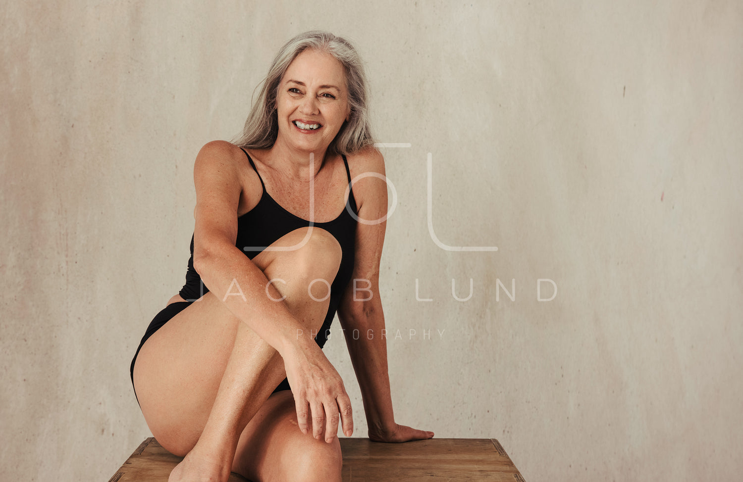 Smiling mature woman embracing her aging body