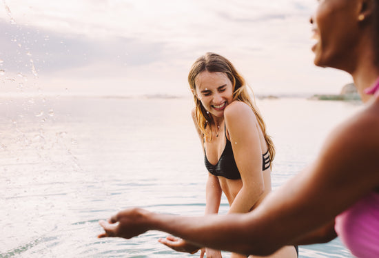 Two happy women sitting on the promenade with beach workout essentials –  Jacob Lund Photography Store- premium stock photo