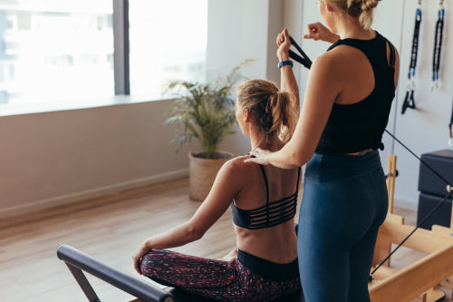 Woman doing pilates training using yoga wheel at the gym – Jacob