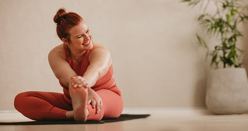 Woman doing yoga while watching instructional videos on laptop – Jacob Lund  Photography Store- premium stock photo