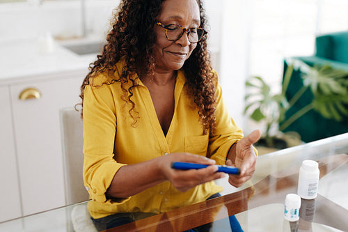 Senior woman controlling her blood sugar levels with an insulin injection