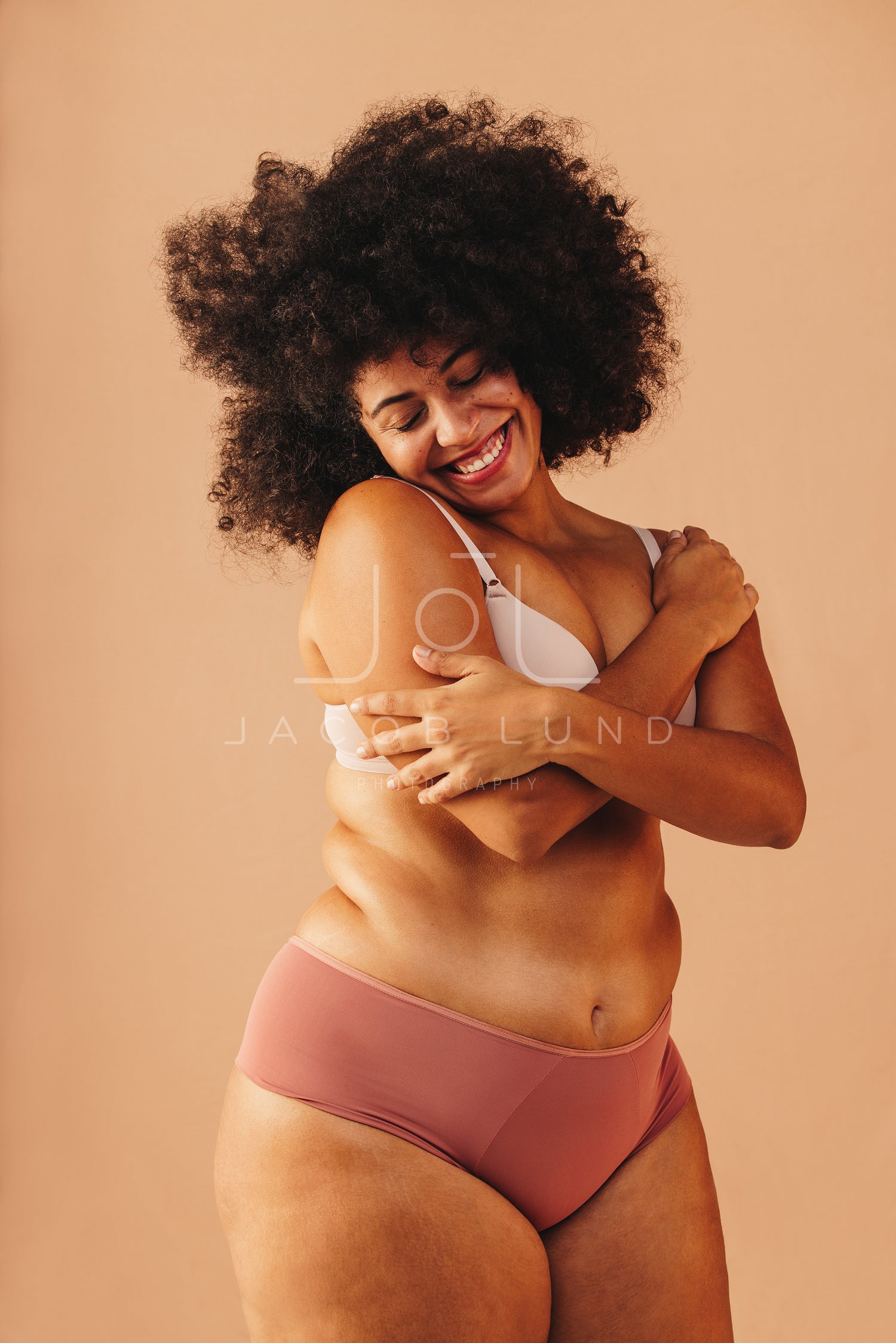 Beautiful plus size woman embracing her body in a studio