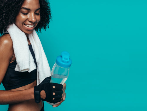 Beautiful woman resting after gym workout holding a plastic water bottle, Stock image