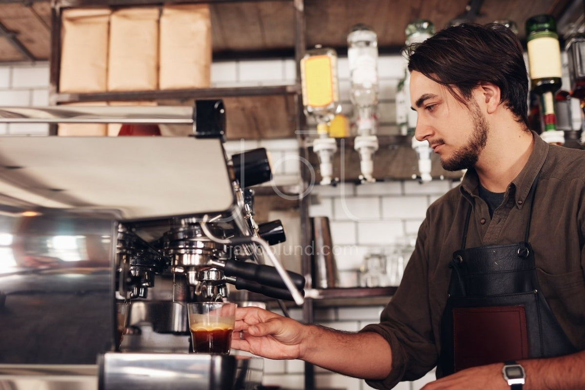 Smiling barista making espresso with a coffee maker – Jacob Lund  Photography Store- premium stock photo