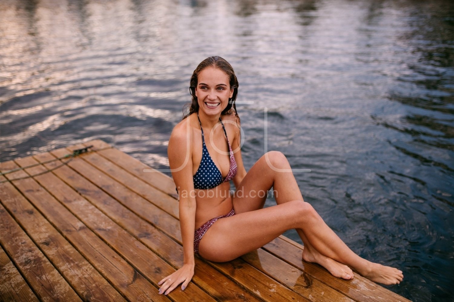 Teenager girl wearing bikini stands in the water of a beautiful lake and  enjoys warm weather at summer vacations Stock Photo