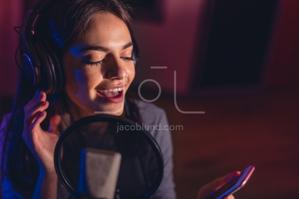 Female singing a sing with mobile phone at recording studio – Jacob ...