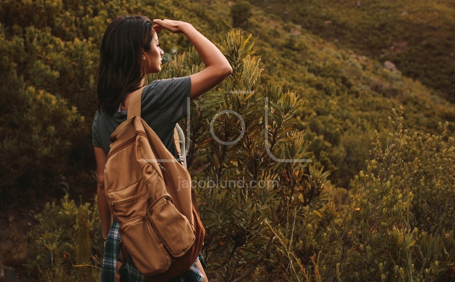 Woman hiking in mountains and looking at the scenic view
