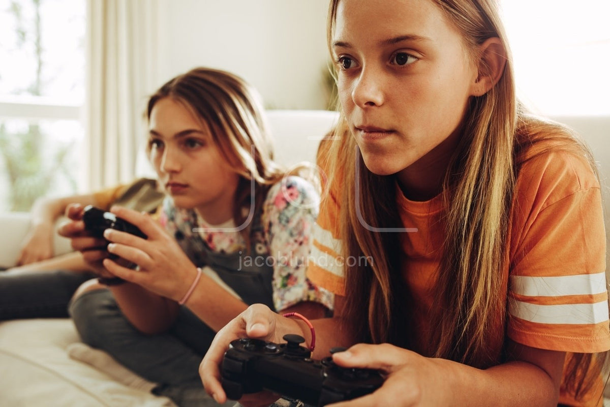 Girls playing video games at home – Jacob Lund Photography Store- premium  stock photo