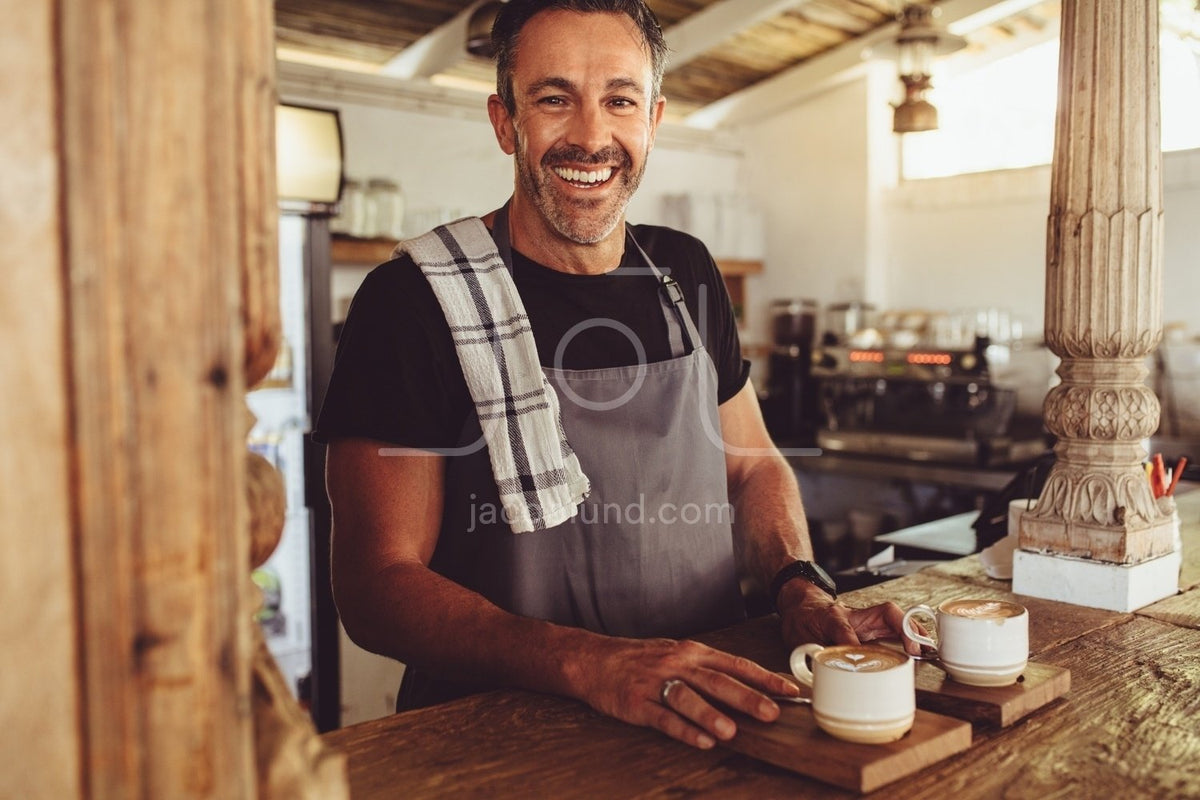 Smiling barista making espresso with a coffee maker – Jacob Lund  Photography Store- premium stock photo