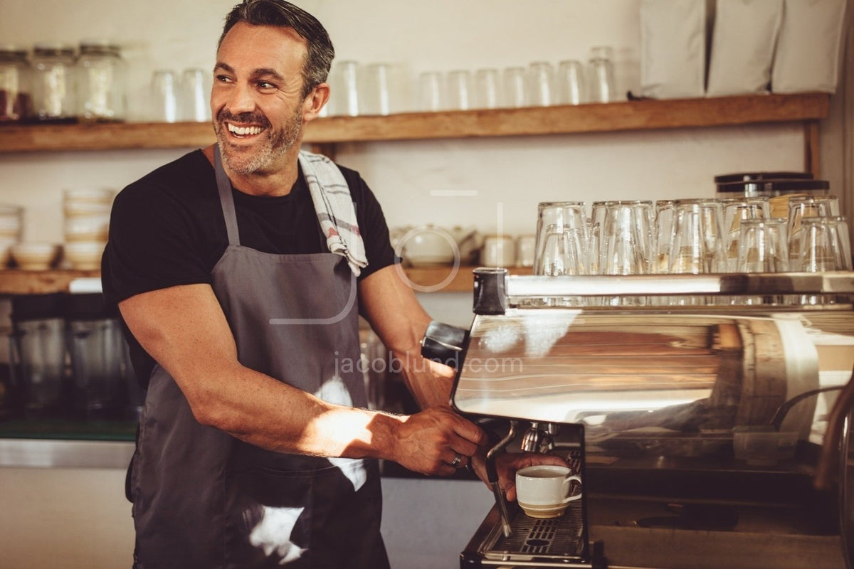 Smiling barista making espresso with a coffee maker – Jacob Lund  Photography Store- premium stock photo