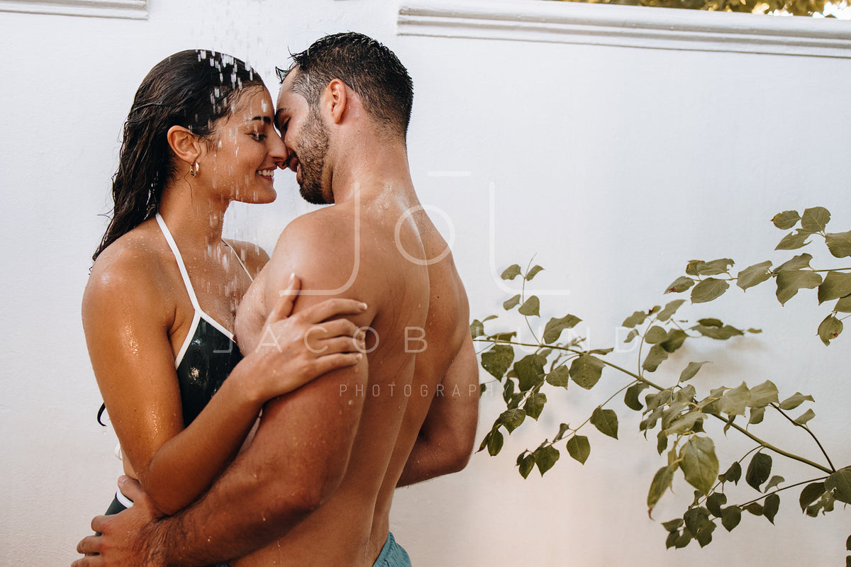 Couple flirting under the shower outdoors – Jacob Lund Photography Store-  premium stock photo