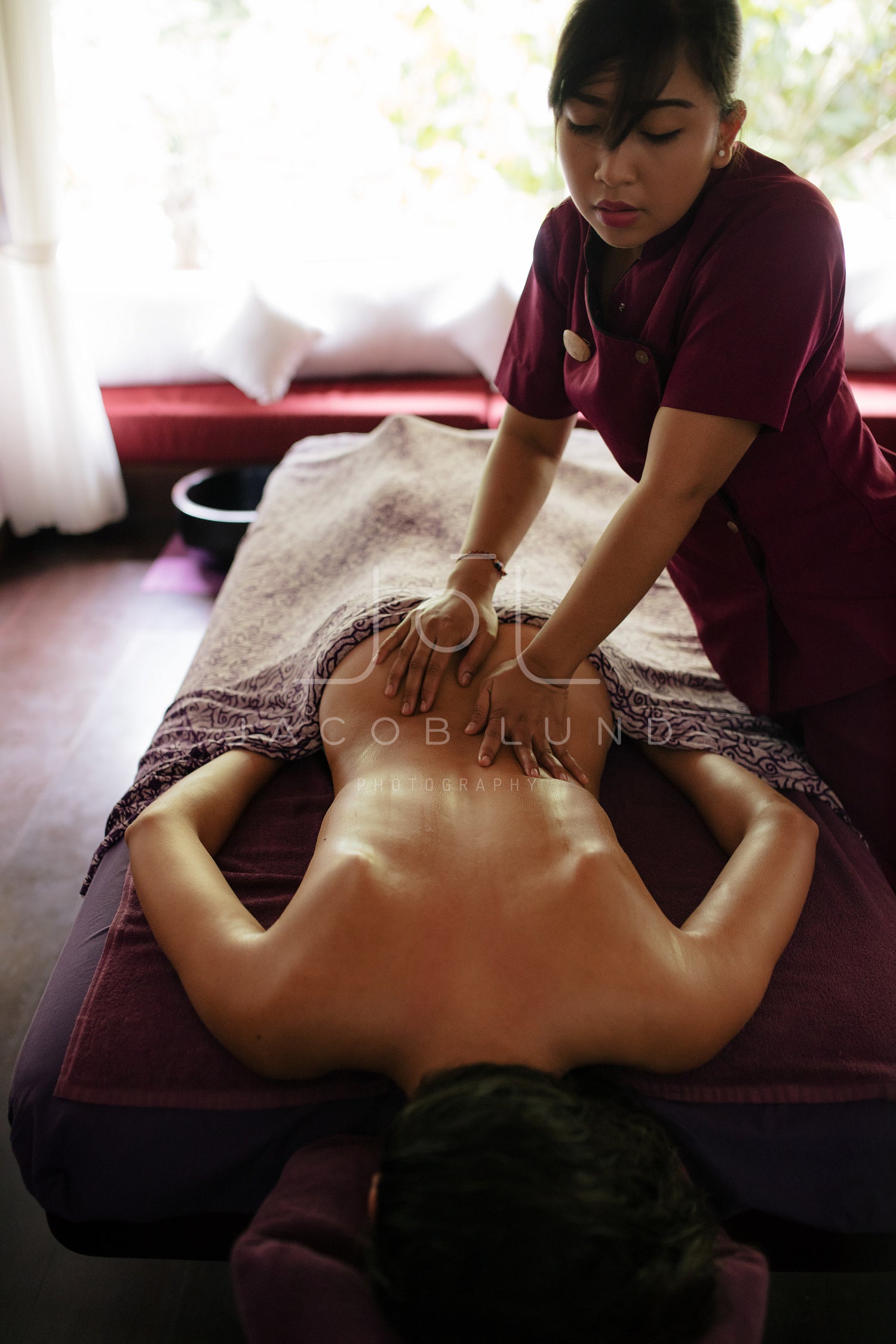 Woman getting back massage at spa resort – Jacob Lund Photography